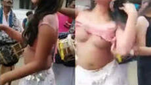 two naked prostitute dance in village, public place, in front of people