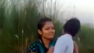 A BOY KISSING A GIRL ON A SCHOOL FIELD