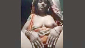 A mature Indian woman is displaying her large breasts and vagina.