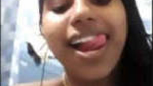 A young Tamil woman washes herself and exposes her skin.