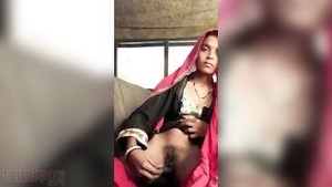 Young woman pleases herself with an purple dildo in a village setting.