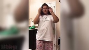 A overweight woman strips and masturbates with her fingers for her lover.