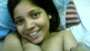 A shy Indian woman is undressed by her lover on the bed.
