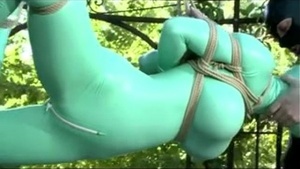 Latex clad babe enjoys outdoor bondage and fucking