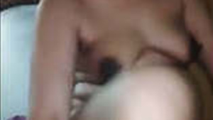 A mature married woman applies lotion to her body while her husband films her.