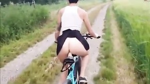 Hot Indian woman riding a bike in a field with a sex toy.