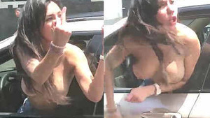 A young Indian woman, topless and yelling outside a car in a public road.